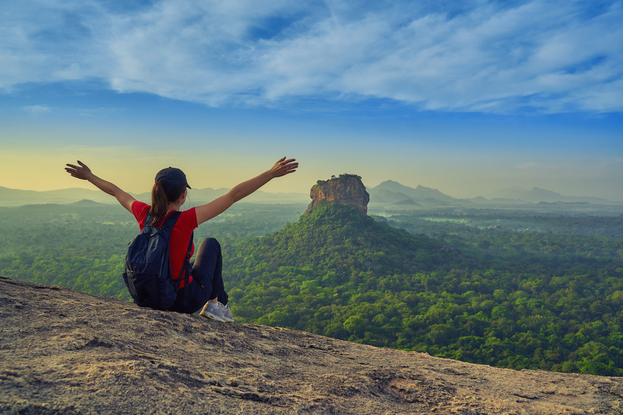 A solo traveler enjoying her view of Sigiriya Rock from Pidurangala Rock