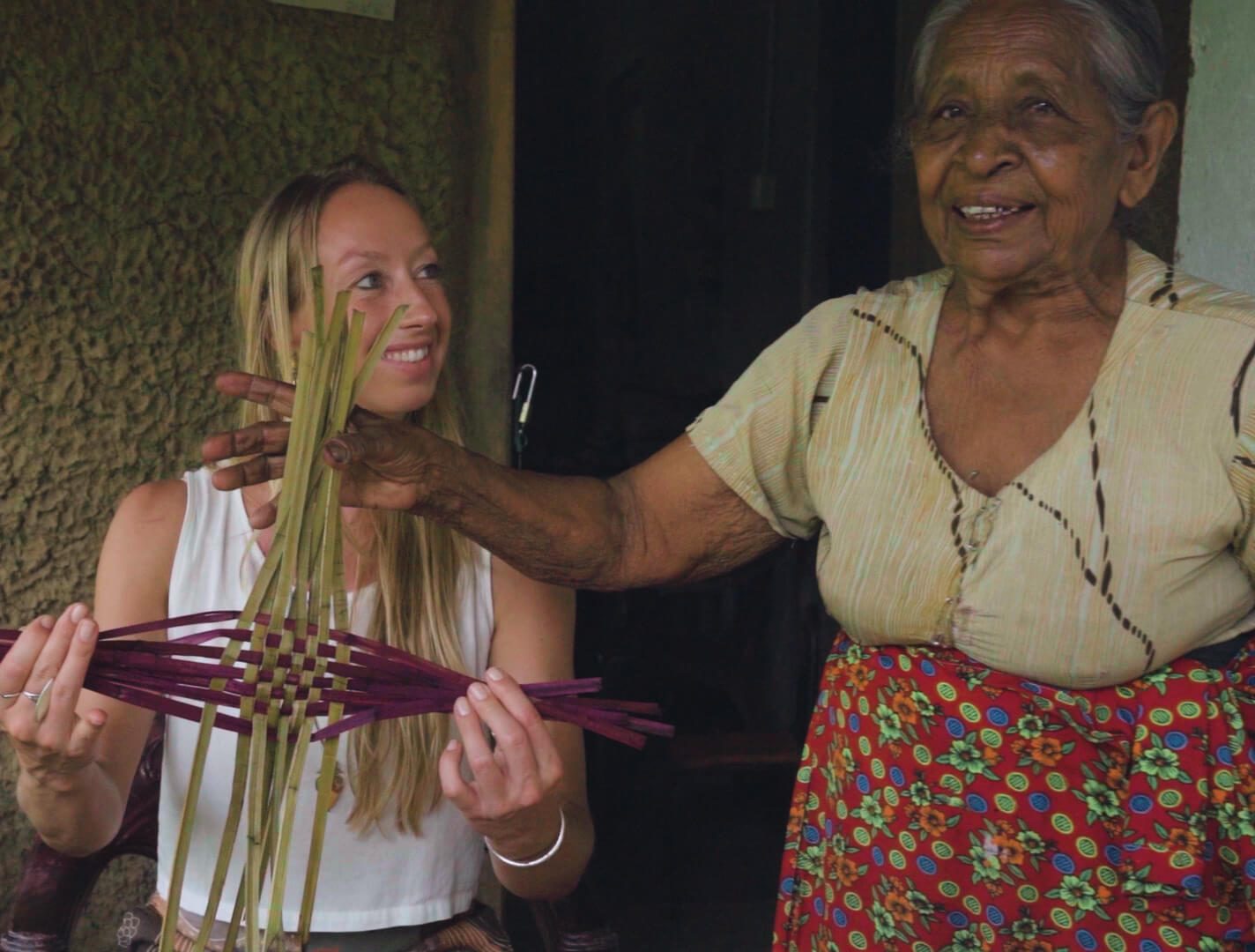 A Sri Lankan handloom artisan weaving coloured thread in a small daylight-lit workshop